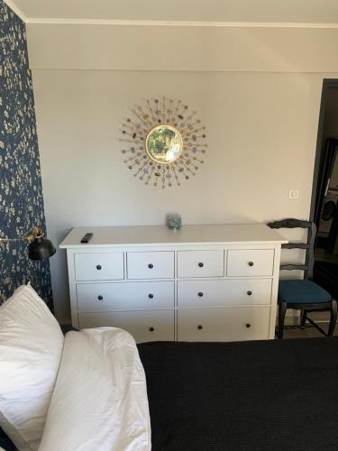 een slaapkamer met een dressoir en een spiegel aan de muur bij Chambre complètement indépendante ! in Limoges