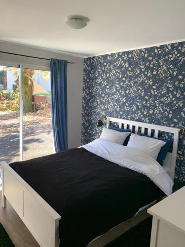 a bedroom with a bed with a floral wallpaper at Chambre complètement indépendante ! in Limoges