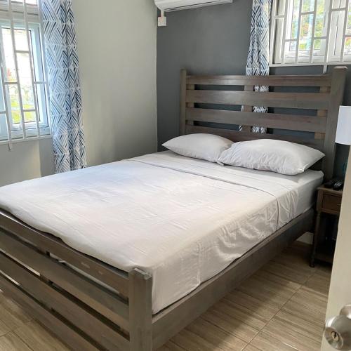 a bed with white sheets and pillows in a bedroom at Travellers Villa in Roseau