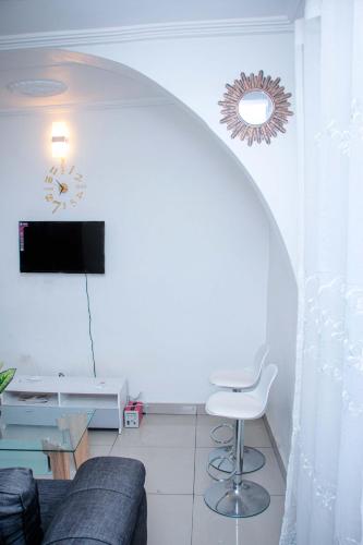 Télévision ou salle de divertissement dans l'établissement NAIVELI-PALM Appartement meublé sobre et chic