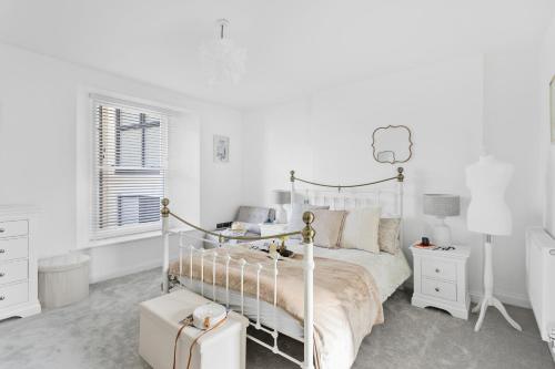 a white bedroom with a white bed and a window at Rutland Heights - Luxury Apartment in Torquay