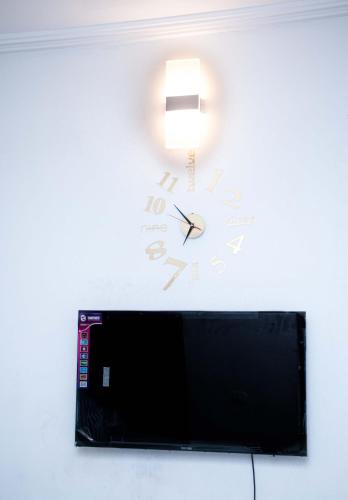 Télévision ou salle de divertissement dans l'établissement NAIVELI-PALM Appartement meublé sobre et chic