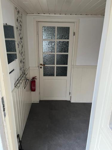a hallway with a white door and a window at Overnatting på Leknes in Leknes
