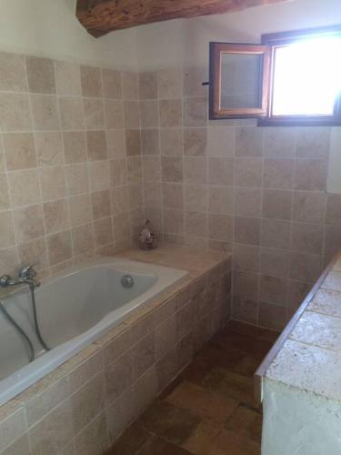 une salle de bain avec une baignoire et une fenêtre dans l'établissement Les Lauriers Roses Palombaggia Porto-Vecchio, à Porto-Vecchio