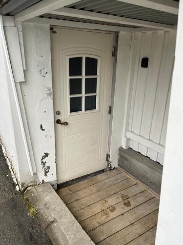 een witte deur op een huis met een veranda bij Overnatting på Leknes in Leknes