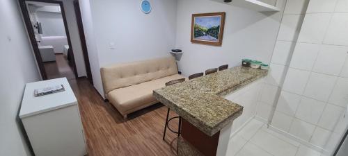 uma sala de estar com um sofá e uma bancada em Flat Pasárgada 906, Free Bikes, pé na praia em Vila Velha