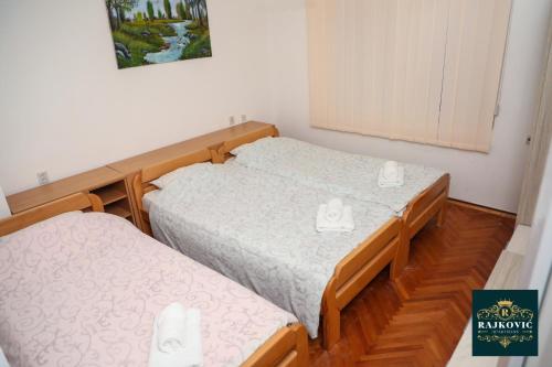 two twin beds in a small room with at Apartmani Rajkovic in Soko Banja