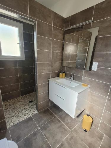 La salle de bains est pourvue d'un lavabo blanc et d'un miroir. dans l'établissement Gîte Tomasini, à Monacia-dʼAullène