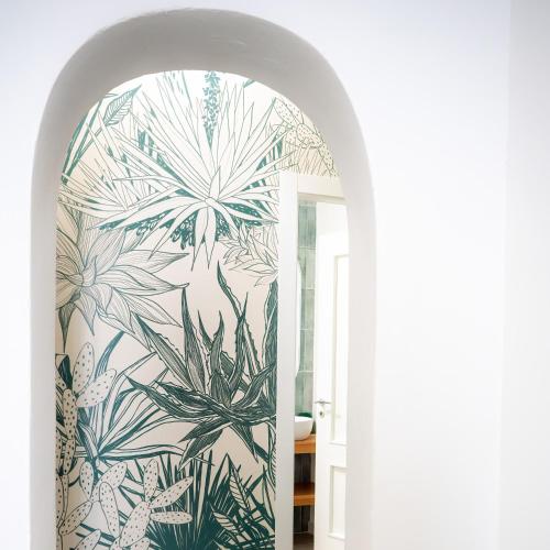 a hallway with a wall mural of plants at Zabbara in Noto