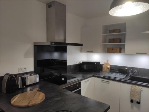 a kitchen with a wooden cutting board on a counter at Calme et verdure à Poissy 50 m2 parking terrasse in Poissy