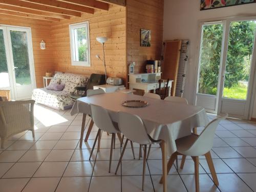 un salon avec une table, des chaises et un canapé dans l'établissement La maison d'Elisa, à Gujan-Mestras