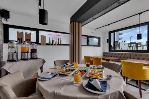 a dining room with a table with food on it at Beach Hotel Božikovina in Podstrana