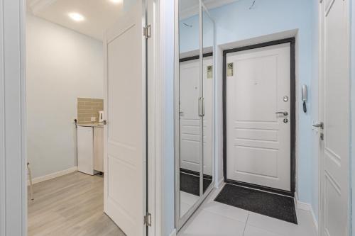 een hal met witte deuren en een spiegel bij Korkem 4-313 Триумфальная Арка in Taldykolʼ