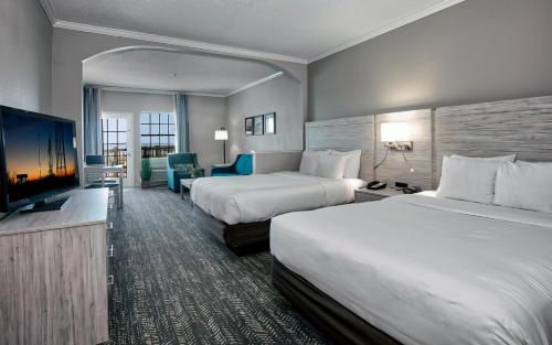 a hotel room with two beds and a flat screen tv at Comfort Suites Chincoteague Island Bayfront Resort in Chincoteague
