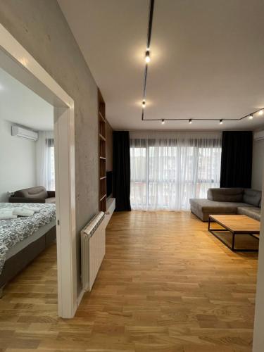a bedroom with a bed and a living room at Leo Lux 2 in Niš