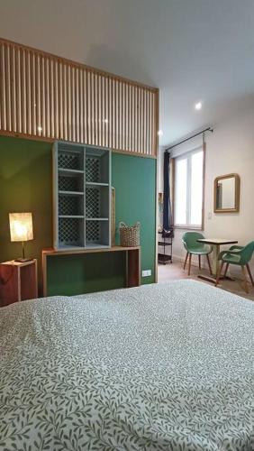a bedroom with a large bed and a table at Le Raffiné in Millau