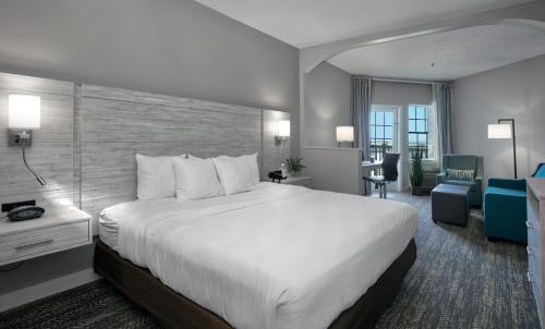a hotel room with a large bed and a desk at Comfort Suites Chincoteague Island Bayfront Resort in Chincoteague