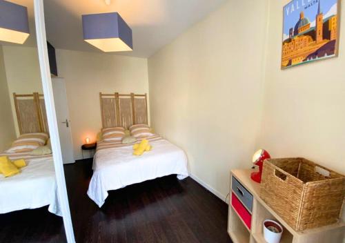 a small bedroom with two beds and a mirror at La Comédie - Poitiers Centre - La Conciergerie. in Poitiers