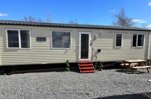 a mobile home with a porch and a picnic table at Marsh Farm Holiday Park in Great Yarmouth