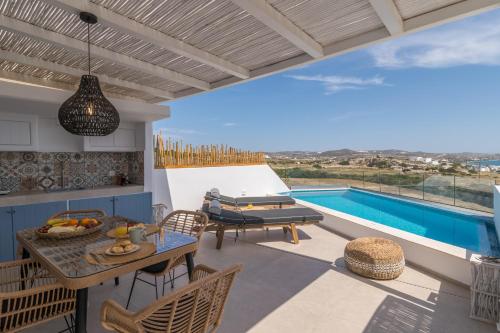 a patio with a table and chairs and a swimming pool at Chrysomelo in Adamas