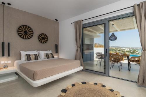 a bedroom with a bed and a balcony at Chrysomelo in Adamas
