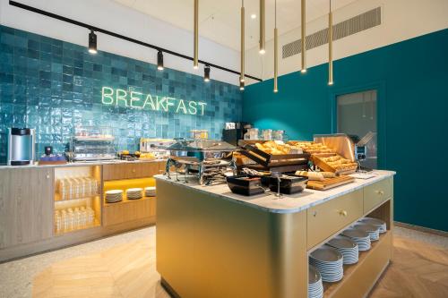 a breakfast restaurant with a counter with food at B&B HOTEL Namur in Namur