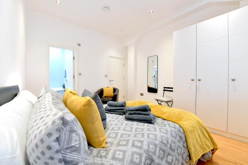 a bedroom with a bed with yellow and gray pillows at Hendon Escape Luxury Apartment with En-suite Bath in Hendon