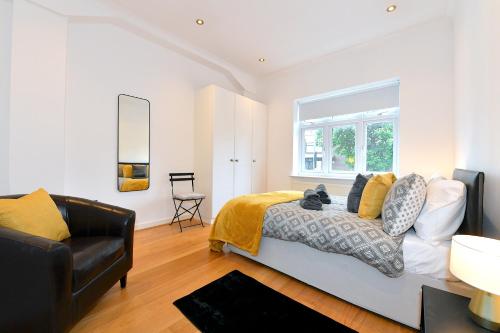 a bedroom with a bed and a black leather chair at Hendon Escape Luxury Apartment with En-suite Bath in Hendon