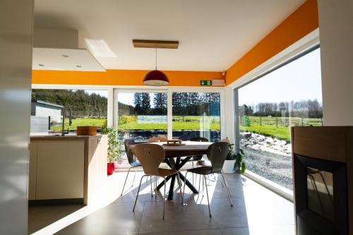 a kitchen and dining room with an orange ceiling at À l'orée de la Fôret in Manhay
