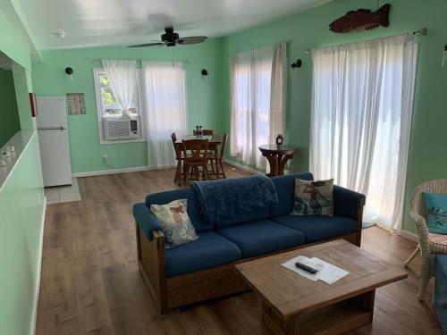 The Boat House - Water Front, WiFi, Pet Friendly home في نورفولك: غرفة معيشة مع أريكة زرقاء وطاولة
