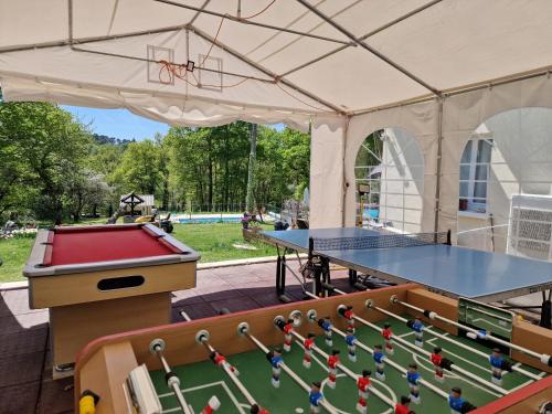 a tent with a ping pong table and a pool table at La Forestine in Bergerac