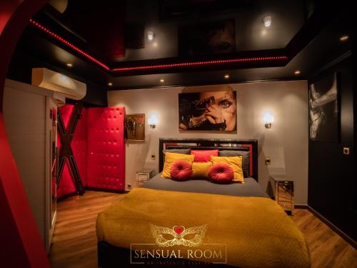 - une chambre dotée d'un lit avec des oreillers jaunes et rouges dans l'établissement Sensual Room Love Room Nancy Sauna Double Douche, à Nancy