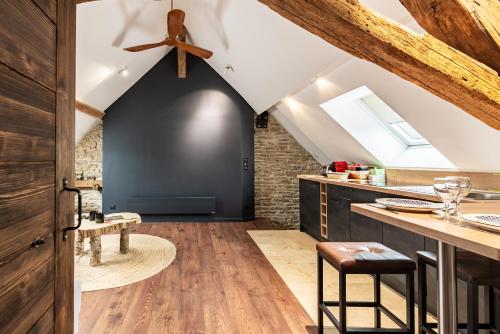 une cuisine mansardée avec un mur noir et des plafonds en bois dans l'établissement SOUS LE HAUT DES REMPARTS, à Beaune