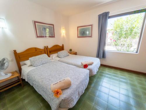 a hotel room with two beds and a window at Casas del Sol in Playa Blanca