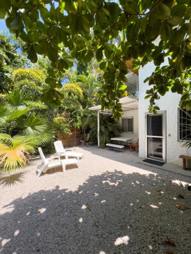a patio with two white benches and a house at Salt Nosara in Nosara