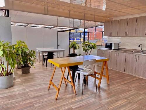 een keuken met een gele tafel en stoelen in een kantoor bij Apartamentos céntricos y cómodos en Chapinero in Bogota