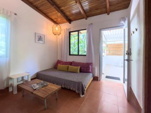 a bedroom with a bed and a table and a window at Salt Nosara in Nosara