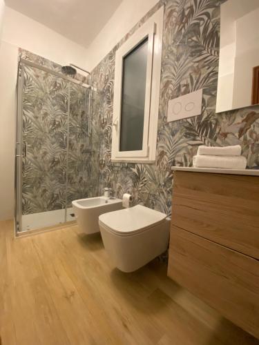 ein Badezimmer mit einem WC, einem Waschbecken und einem Spiegel in der Unterkunft Casa Dominique in Cefalú