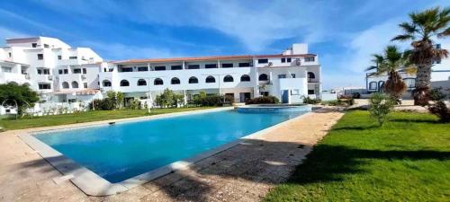 a large white house with a swimming pool in front of it at Charming One Bed Flat in Sagres in Sagres