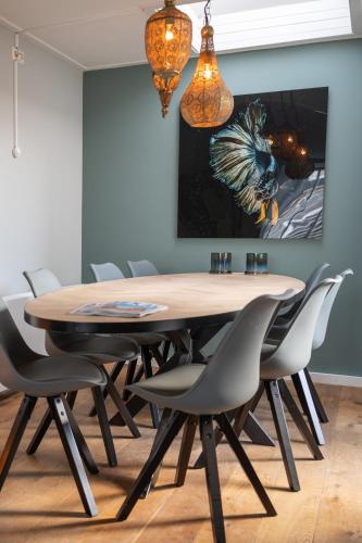 a dining room with a wooden table and chairs at Beach House Makai - family house with Finnish Sauna, 2 bathrooms and only minutes from the Beach in De Koog