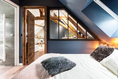 ein Schlafzimmer mit einem Bett und einem großen Fenster in der Unterkunft SOUS LE HAUT DES REMPARTS in Beaune