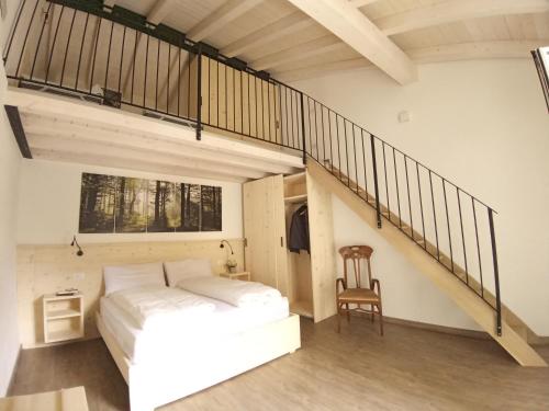 a bedroom with a white bed and a staircase at appartamenti Residenza 1928 in Tremosine Sul Garda