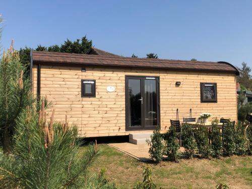 a tiny house in a yard with a patio at Family Woodlodge High Chaparral in Oorsbeek