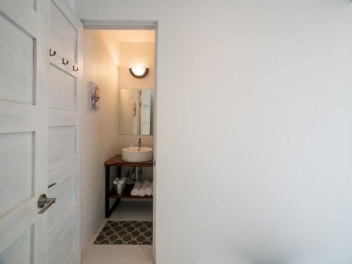 a bathroom with a white door and a sink at Salt Nosara in Nosara