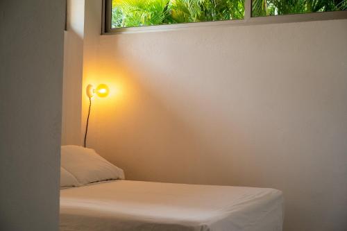 a bedroom with a bed and a window at Salt Nosara in Nosara