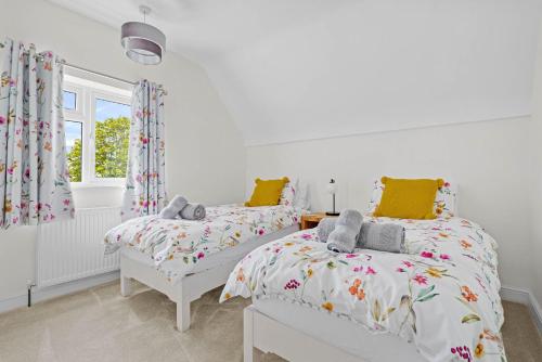 1 Schlafzimmer mit 2 Betten und einem Fenster in der Unterkunft Wheelbarrow Cottage in Bengeworth
