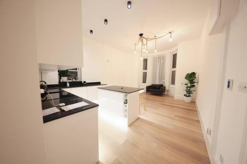 a white kitchen with a counter top in a room at Beautiful brand-new flat in London