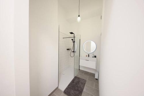 a white bathroom with a shower and a mirror at Beautiful brand-new flat in London