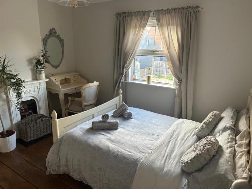 1 dormitorio con cama blanca y ventana en April Cottage Ringwood en Ringwood