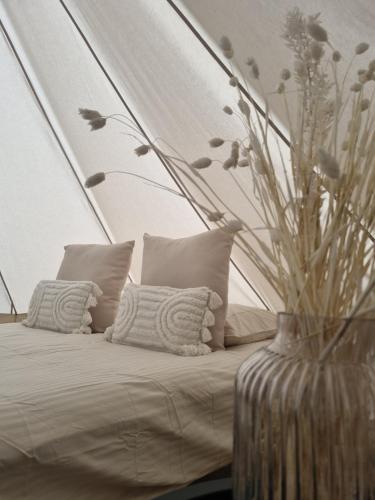 um quarto com uma cama com um vaso com flores em Camping les lodges du Tarn em Mostuéjouls